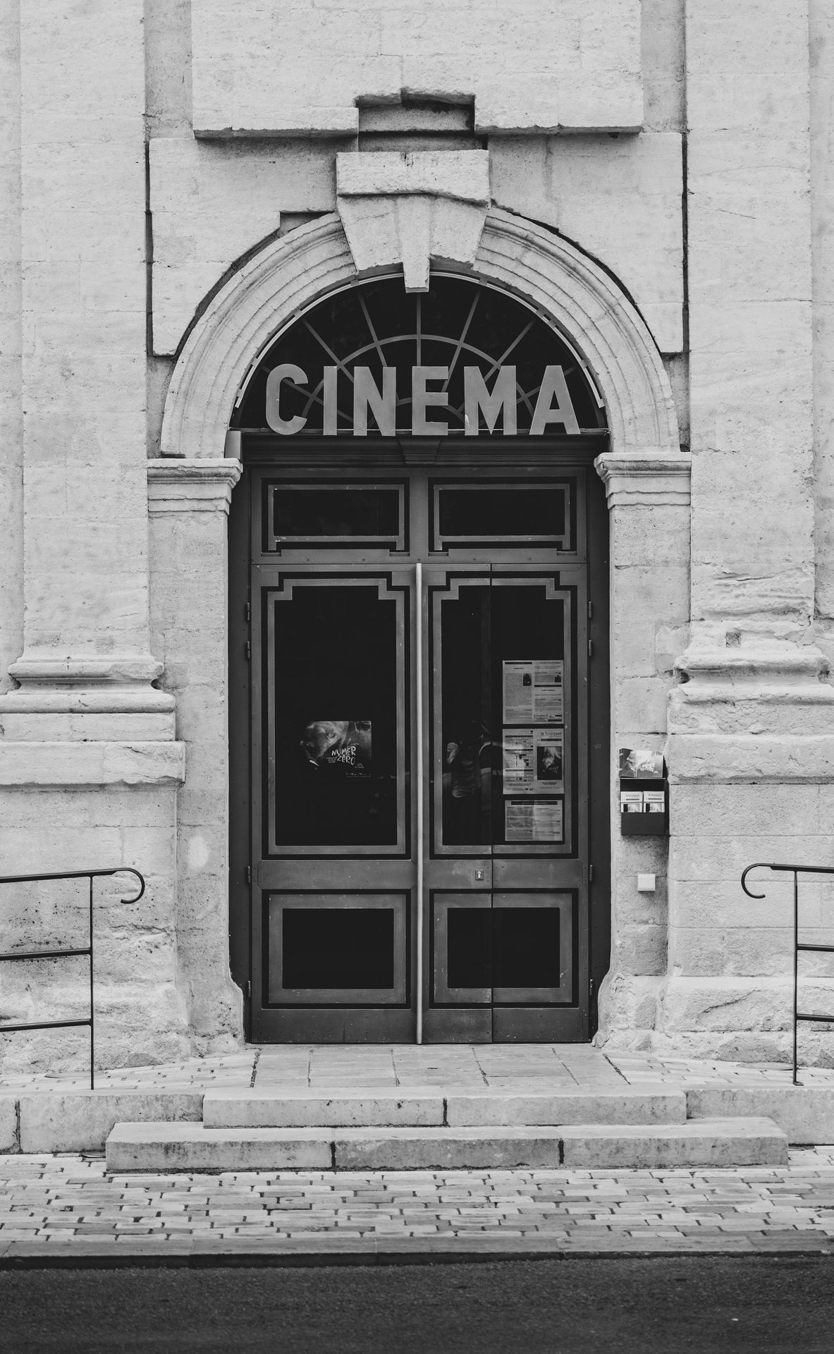 a black and white photo of a cinema entrance